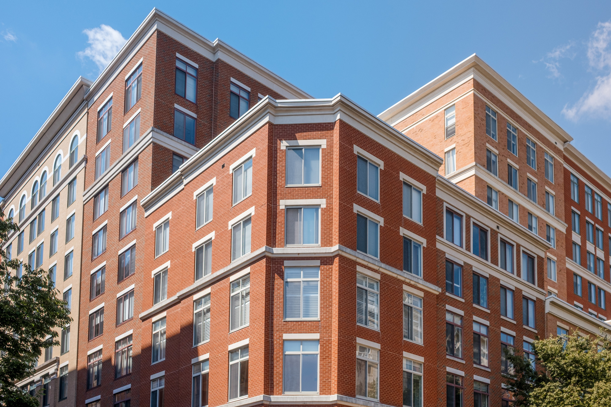 Flerbostadshus med renoverade fönster och välskött fasad i tegel