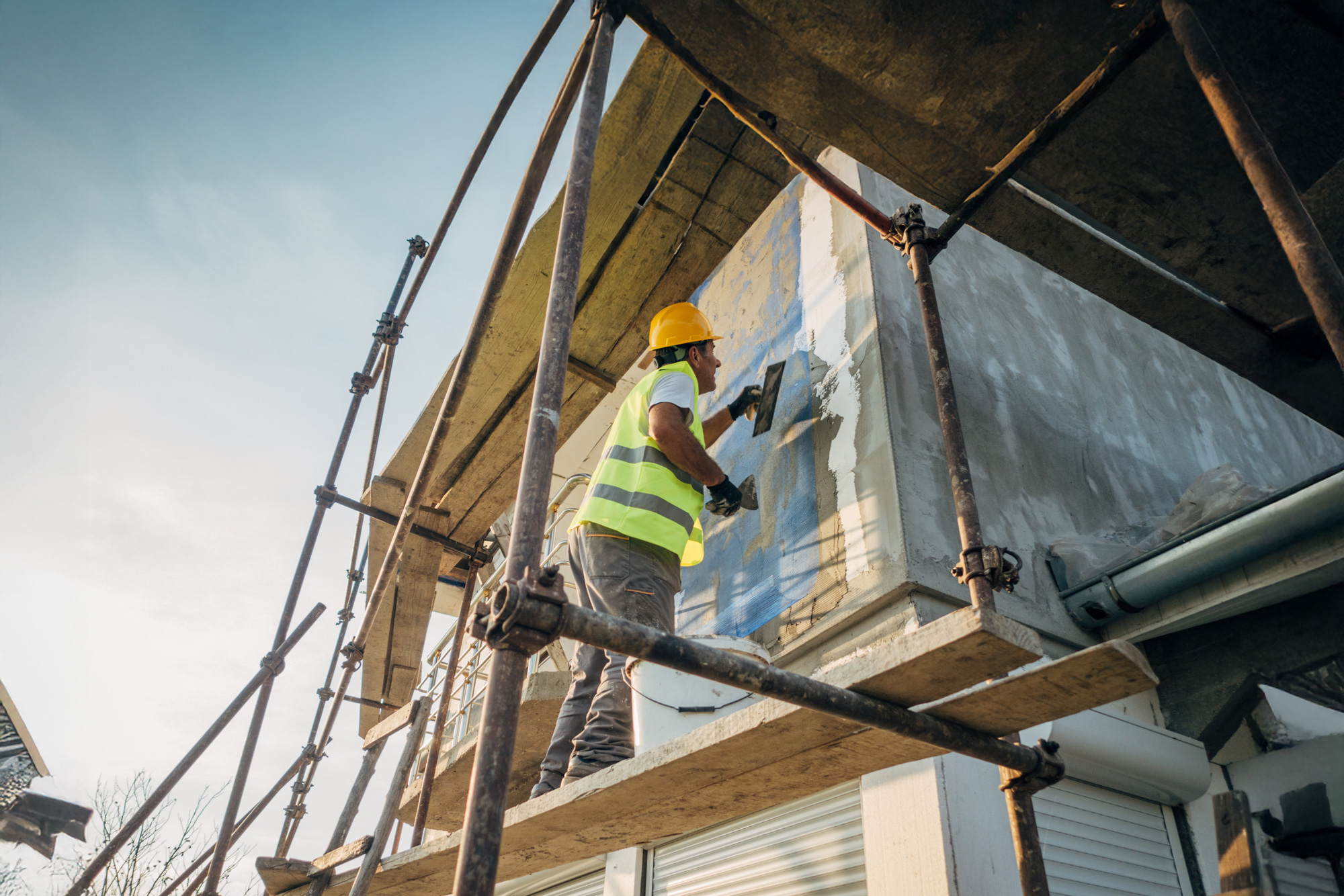 En man arbetar med fasaden